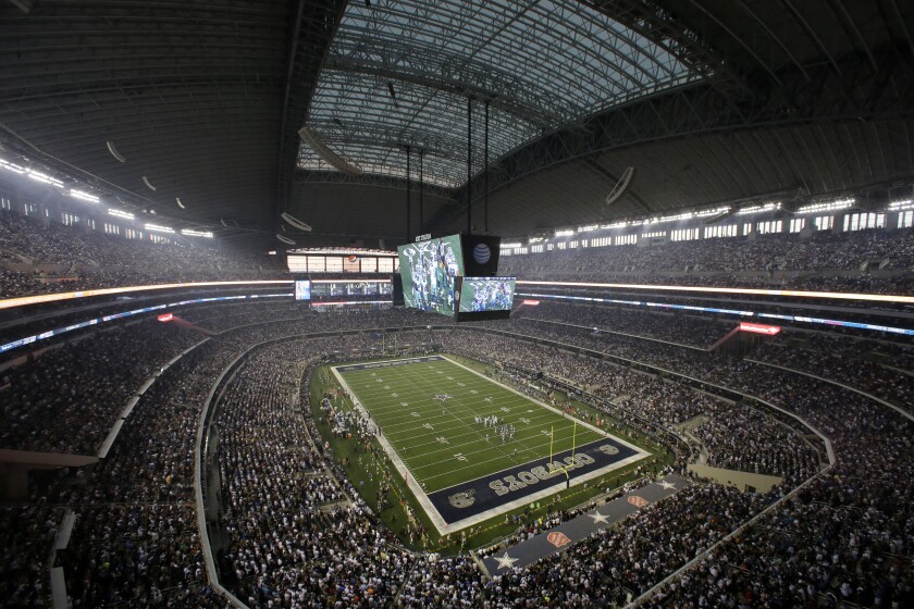 FILE - Fans watch at the start of an NFL football game inside AT&T Stadium between the New York Giants and Dallas Cowboys, on Sept. 8, 2013, in Arlington, Texas. The Dallas Cowboys sparked criticism on social media Tuesday, July 5, 2022, after announcing a marketing agreement with a gun-themed coffee company with blends that include “AK-47 Espresso,” “Silencer Smooth” and “Murdered Out.” The partnership with the Black Rifle Coffee Co. was revealed on Twitter the day after six people died in a shooting at a Fourth of July parade in suburban Chicago. (AP Photo/Tony Gutierrez, File)