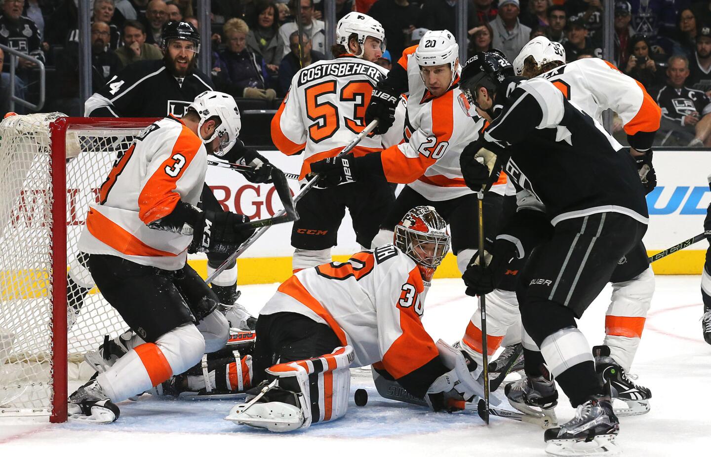 Kings center Trevor Lewis tries to poke the puck past Flyers goalie Michal Neuvirth in the first period Saturday.