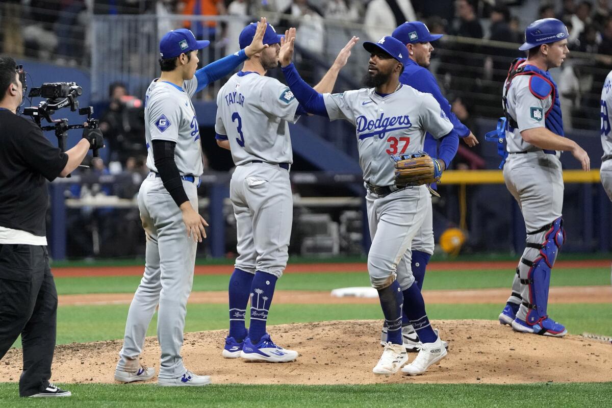 Designated hitter Shohei Ohtani, second from left, congratulates Teoscar Hernández after the Dodgers defeated the Padres.