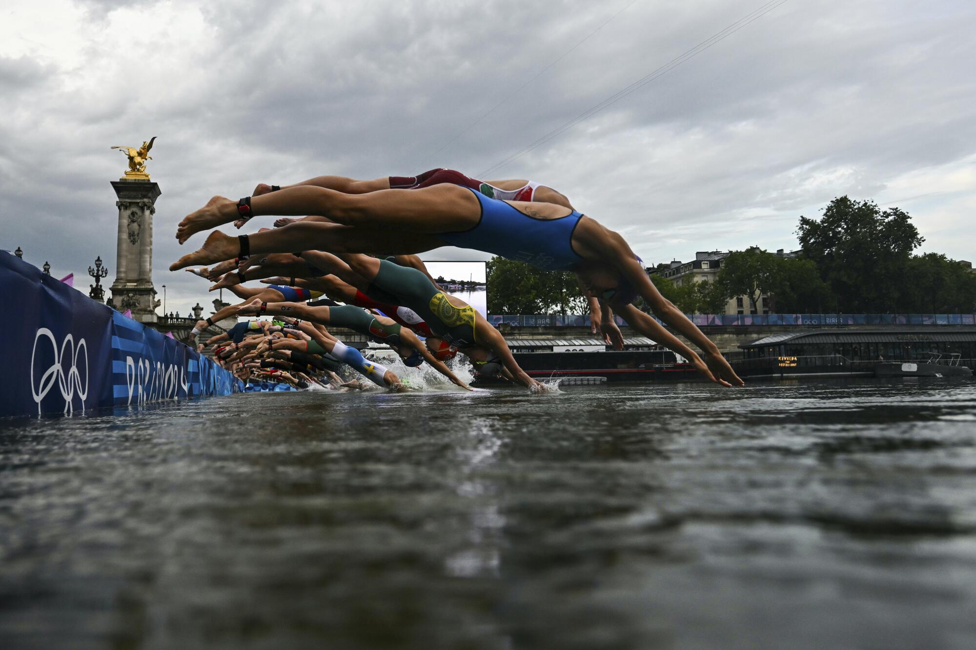 Athletes competing in the women's triathlon dive into the Seine River in Paris on Wednesday.