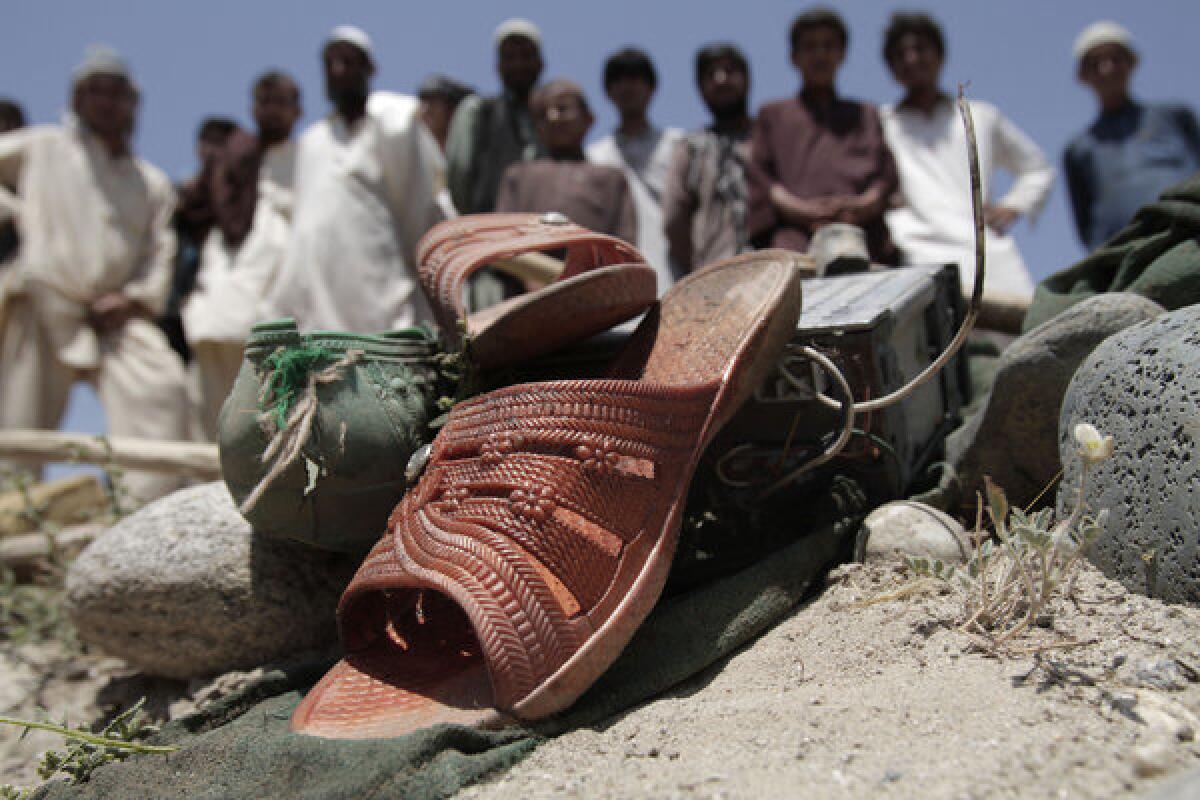 Afghans look at shoes that remained at the scene after a vehicle was hit by a roadside bomb in the Alingar district of Laghman province, east of Kabul, Afghanistan, on Monday. A statement from the provincial government said a group of four women and two children had gone with a male driver into the hills to collect firewood. On their way back, their vehicle hit the mine and all inside were killed.