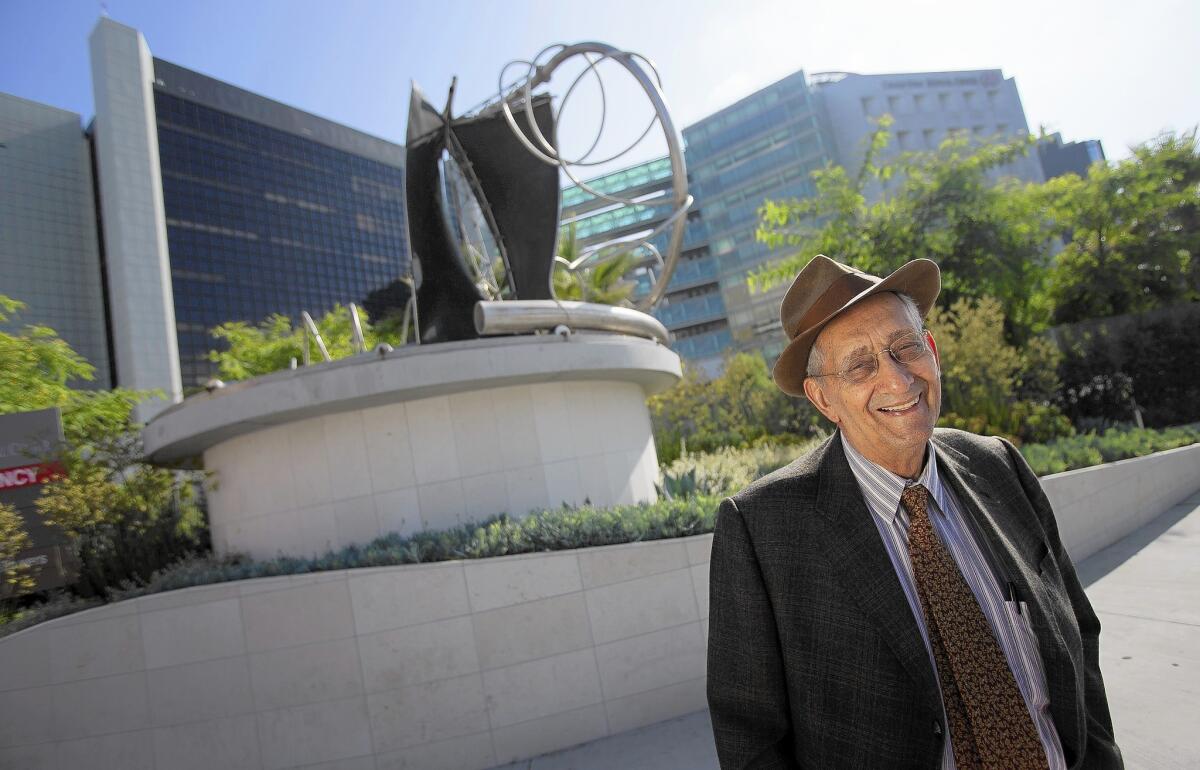 Artist Frank Stella stands beside his scuplture "Adjoeman," which was created in 2004. The sculpture has been installed at the intersection of Beverly and San Vicente boulevards, in front of Cedars-Sinai Medical Center.