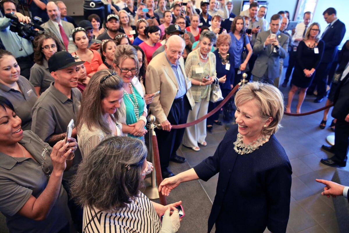 Hillary Rodham Clinton, right, meets with Intertech employees after a tour of Intertech Plastics in Denver.