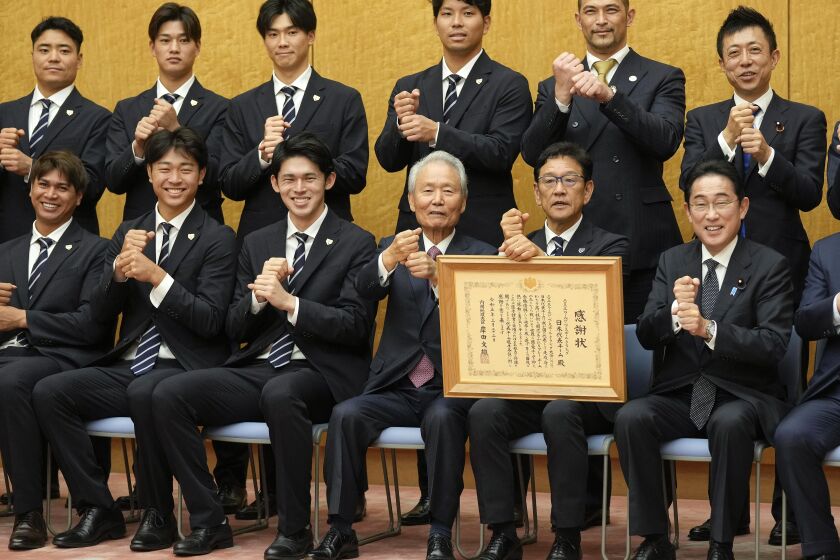 El mánager de la selección de béisbol de Japón, Hideki Kuriyama (segundo a la derecha) y el primer ministro japonés Fumio Kishida, a su lado en la primera fila, posan en la residencia oficial de Kishida, el jueves 23 de marzo de 2023. Japón ganó el Clásico Mundial de béisbol. (Kimimasa Mayama/Pool Foto vía AP)
