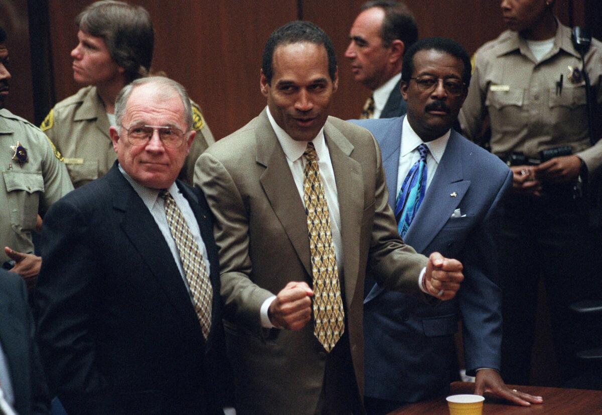 (l-r) F. Lee Bailey, O.J. Simpson and Johnnie Cochran listen to the verdict as it is delivered in Simpson's double murder trial.