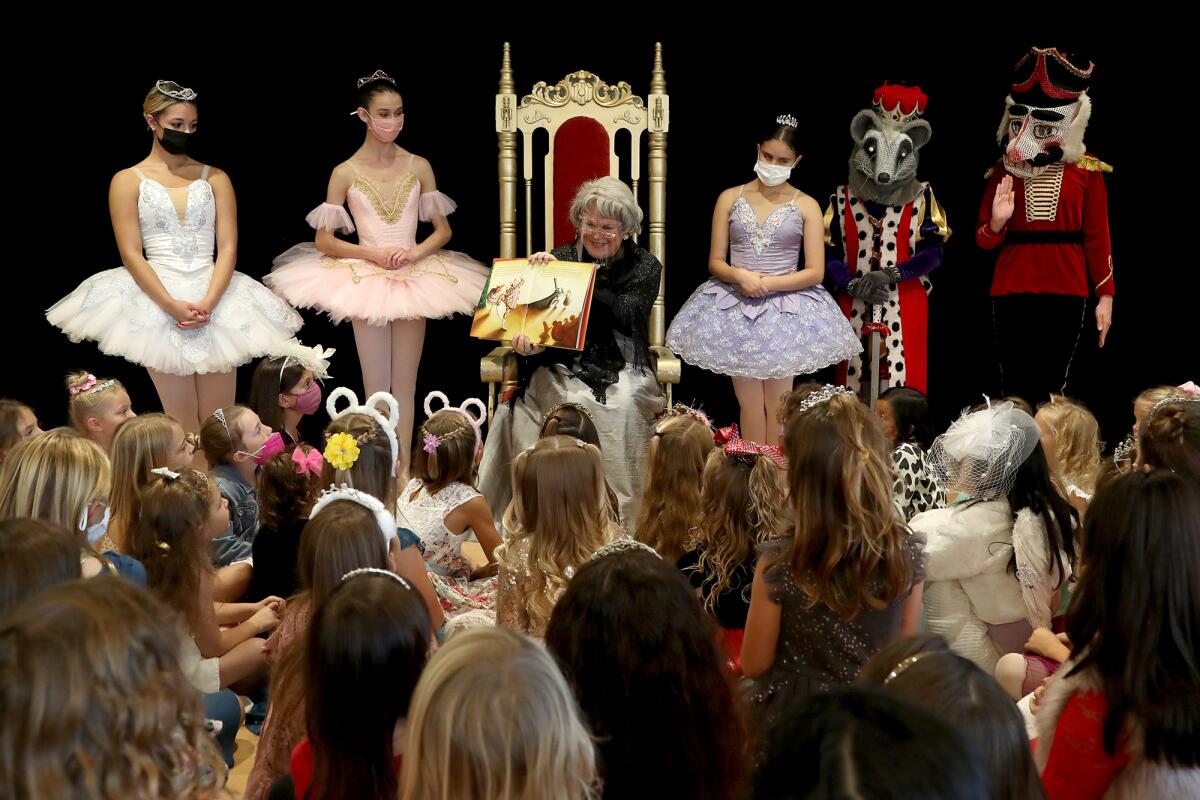 Jana Acciacca, center, as "Nana Jana," reads a fairy tale as she is accompanied by "The Nutcracker" characters on stage.