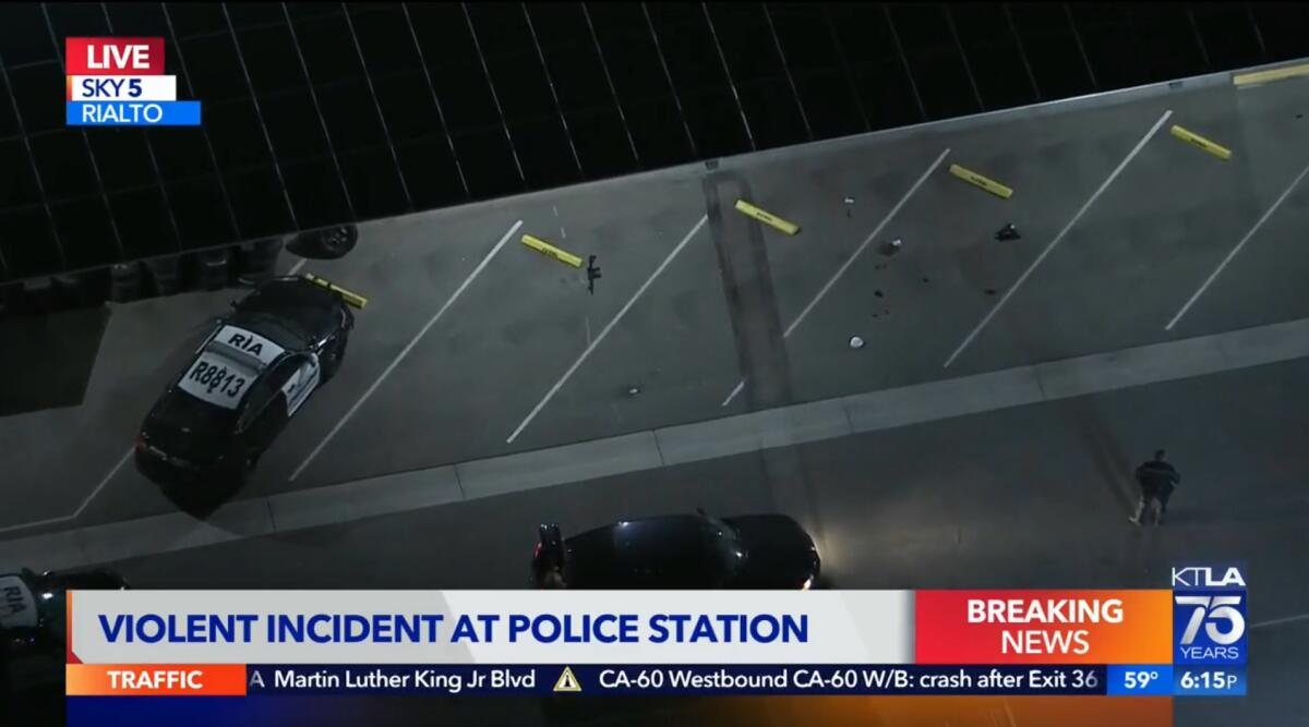 Aerial view of a police parking lot with what appears to be a rifle lying in a spot near blood stains