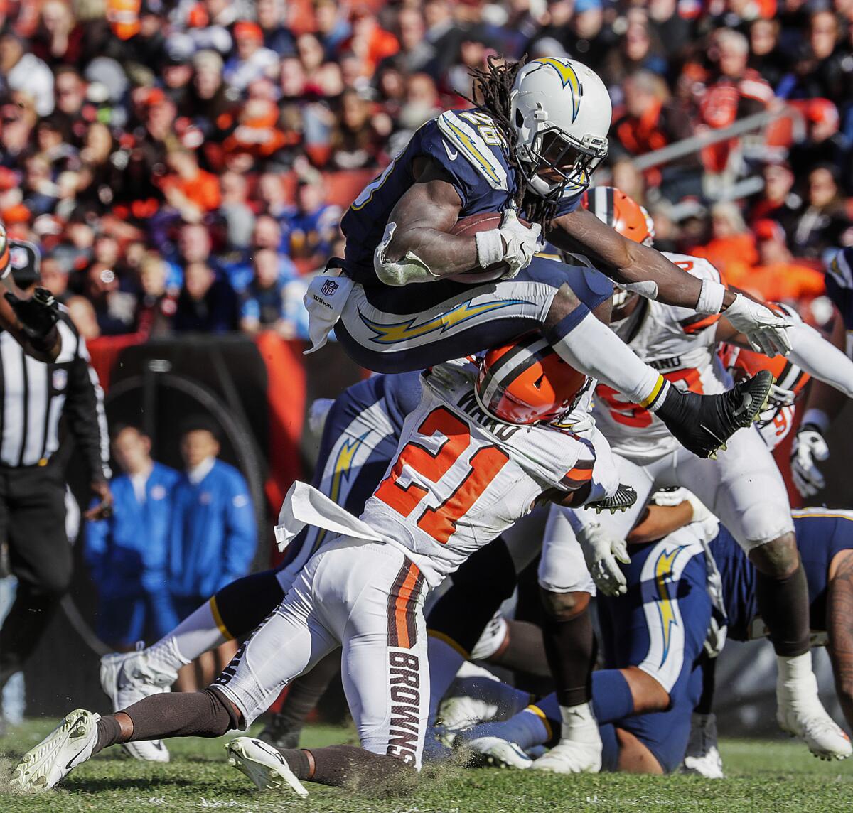 Chargers running back Melvin Gordon leaps over Cleveland Browns defensive back Denzel Ward on a second half run.