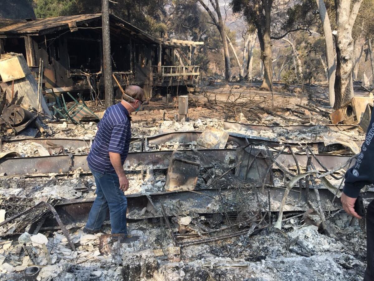 David Spence inspects the burned-out shell of his home in Oak Forest Estates.