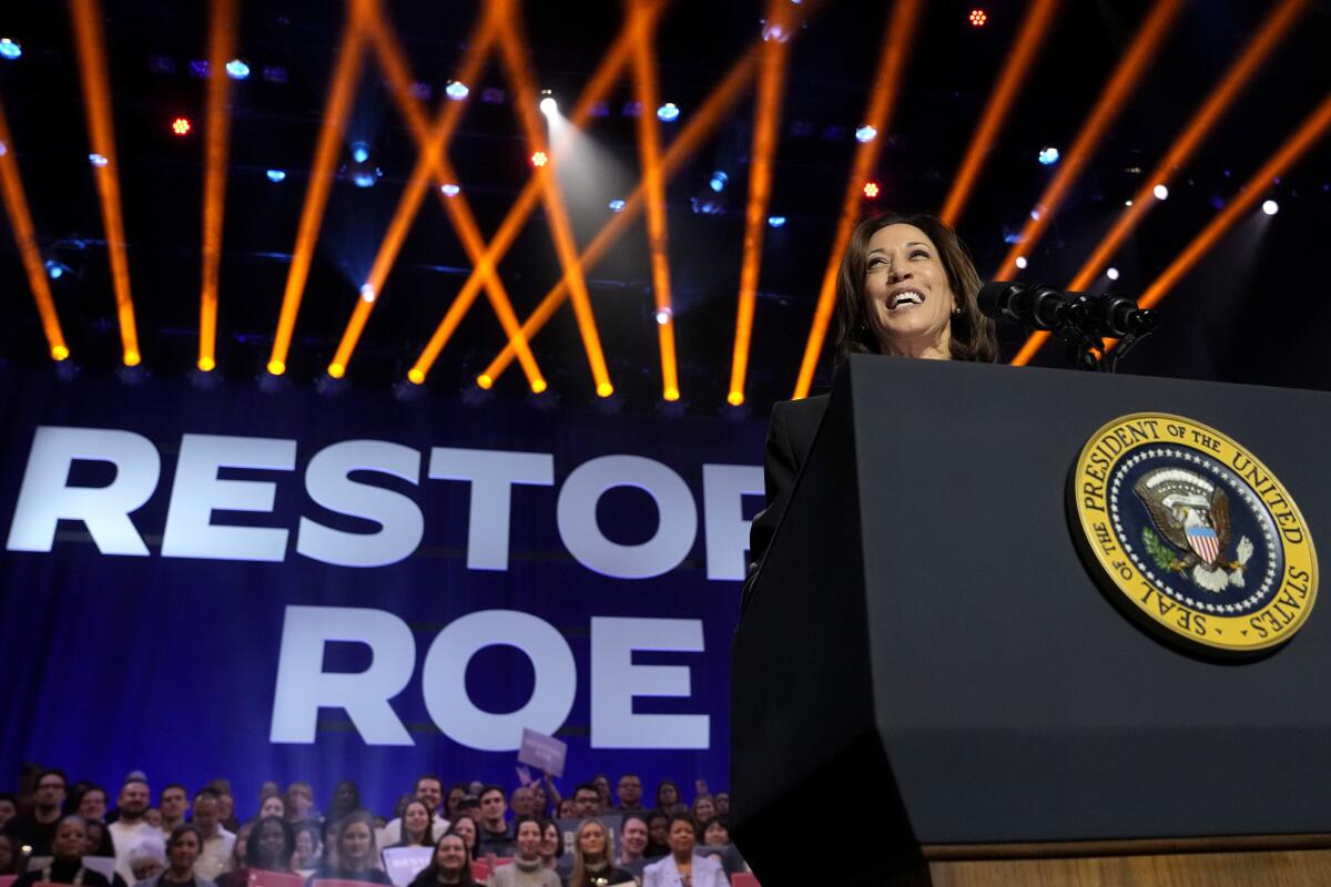Kamala Harris in front of a sign reading "Restore Roe."