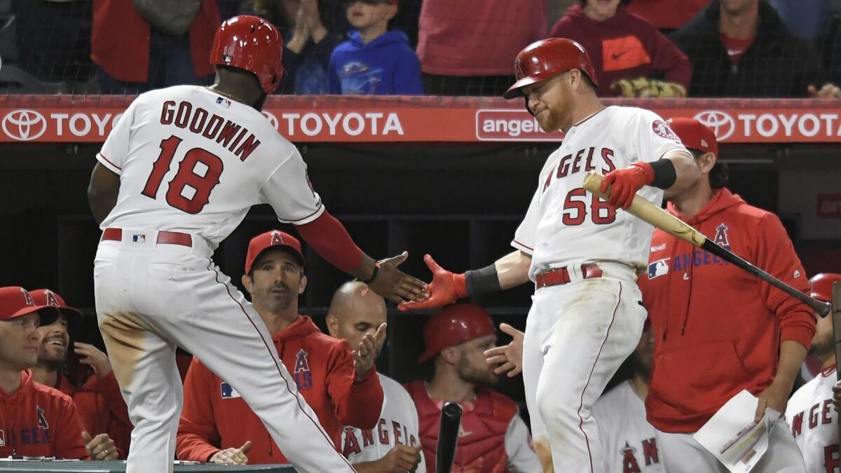 Angels outfielder Brian Goodwin is congratulated by teammate Kole Calhoun after he scored a run during the seventh inning of what later became a loss to the Seattle Mariners at Angel Stadium on April 18.