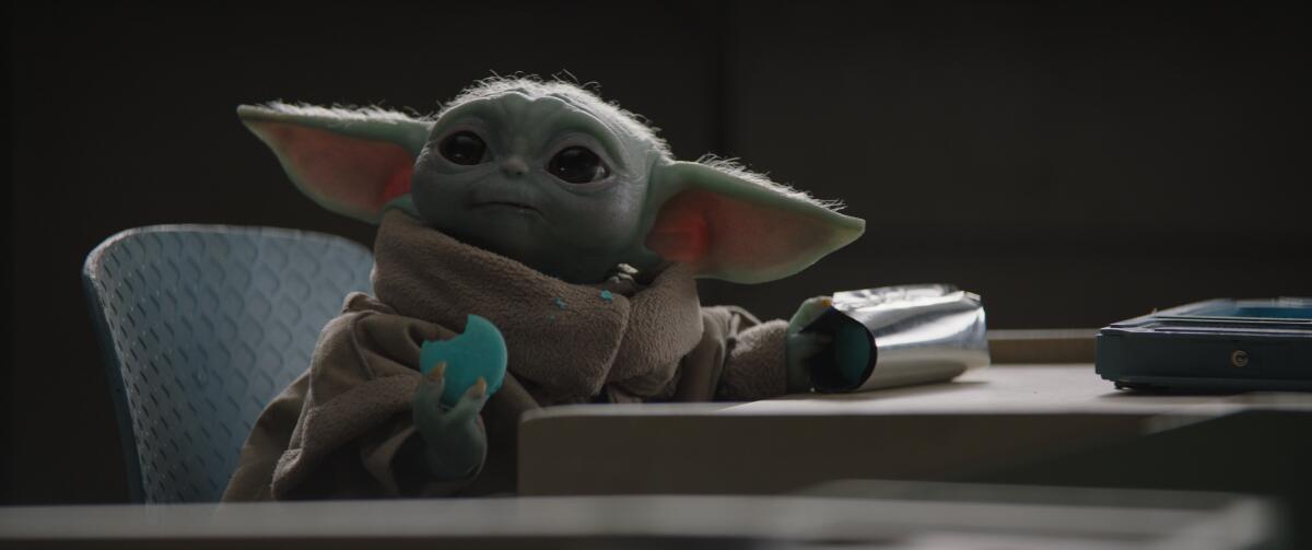 Baby Yoda holding a cookie