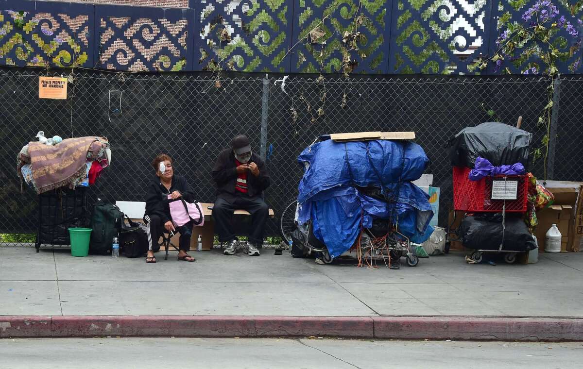 Homeless residents sit beside their belongings in downtown Los Angeles on May 12.