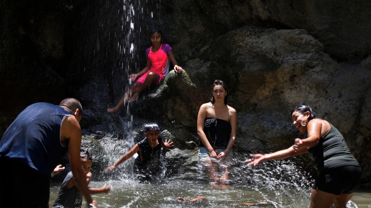 Hikers gather at the base of Eaton Canyon Falls in the Angeles National Forest area. Several people have died and many more have been injured in recent years trying to hike and scale the high walls of the canyon.