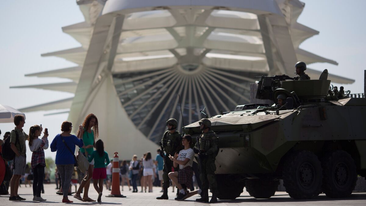 People take pictures with marines and an armored vehicle in Rio de Janeiro on July 9. Roughly twice the security contingent at the London Summer Olympics will be deployed during the August games in Rio.