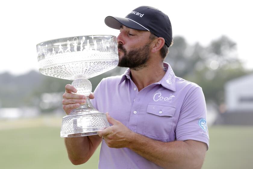 Stephan Jaeger kisses the trophy as he poses for photos during ceremonies after his win in the final round of the Houston Open golf tournament Sunday, March 31, 2024, in Houston. (AP Photo/Michael Wyke)