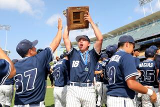 LOS ANGELES, CA - MAY 27: Birmingham Charter starting pitcher Kaden Taque (18) lifts the championship trophy.