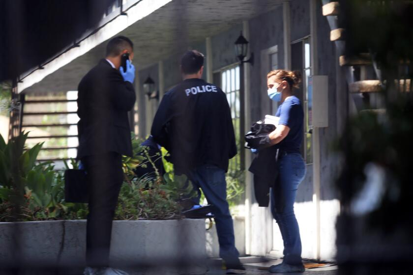 Investigators stand outside a crime scene at the home on the 600 block of West Wilson Boulevard in Glendale where authorities found a woman and her mother violently assaulted on Friday, July 19, 2019. (photo by James Carbone)