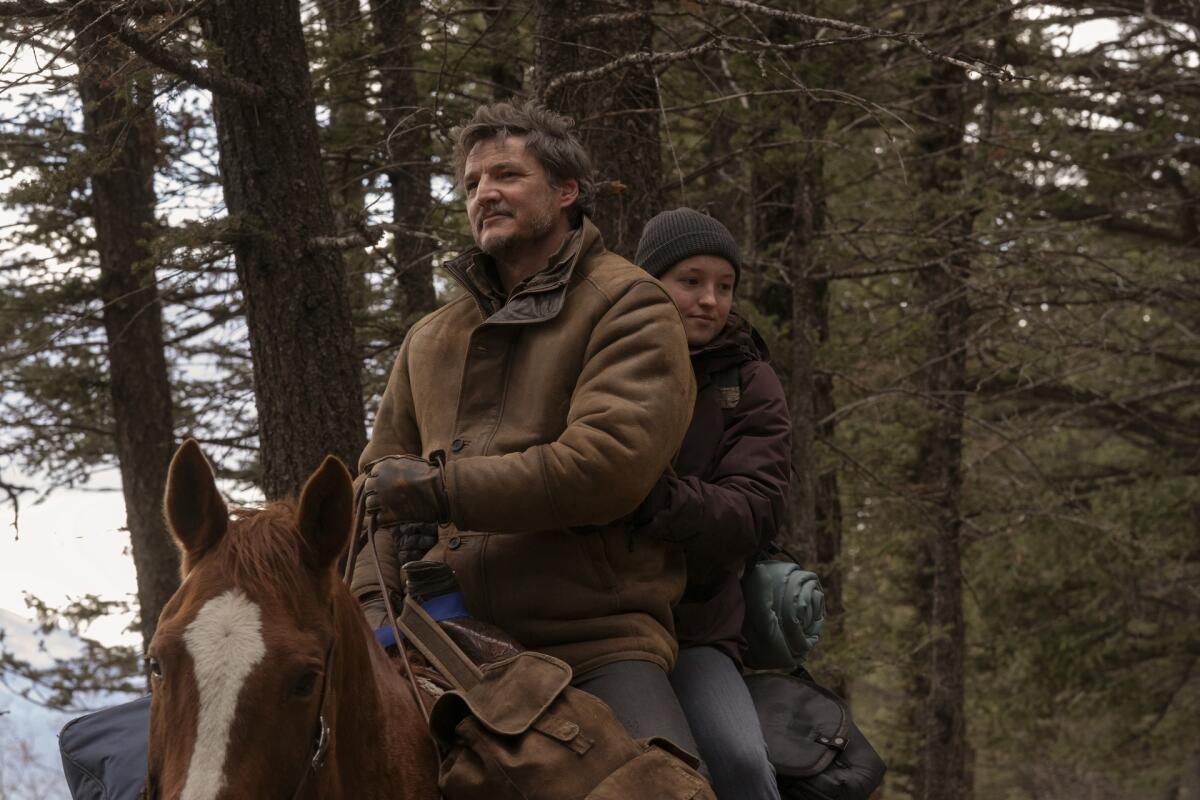 A man and a teenage girl on a horse in the woods.