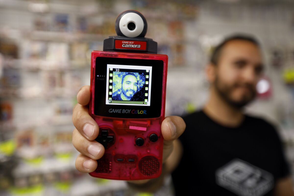 Guillermo Hernandez shows his modified Game Boy Color with a camera and his image on the screen. The handheld, fourth in the Game Boy line, was released in 1998.