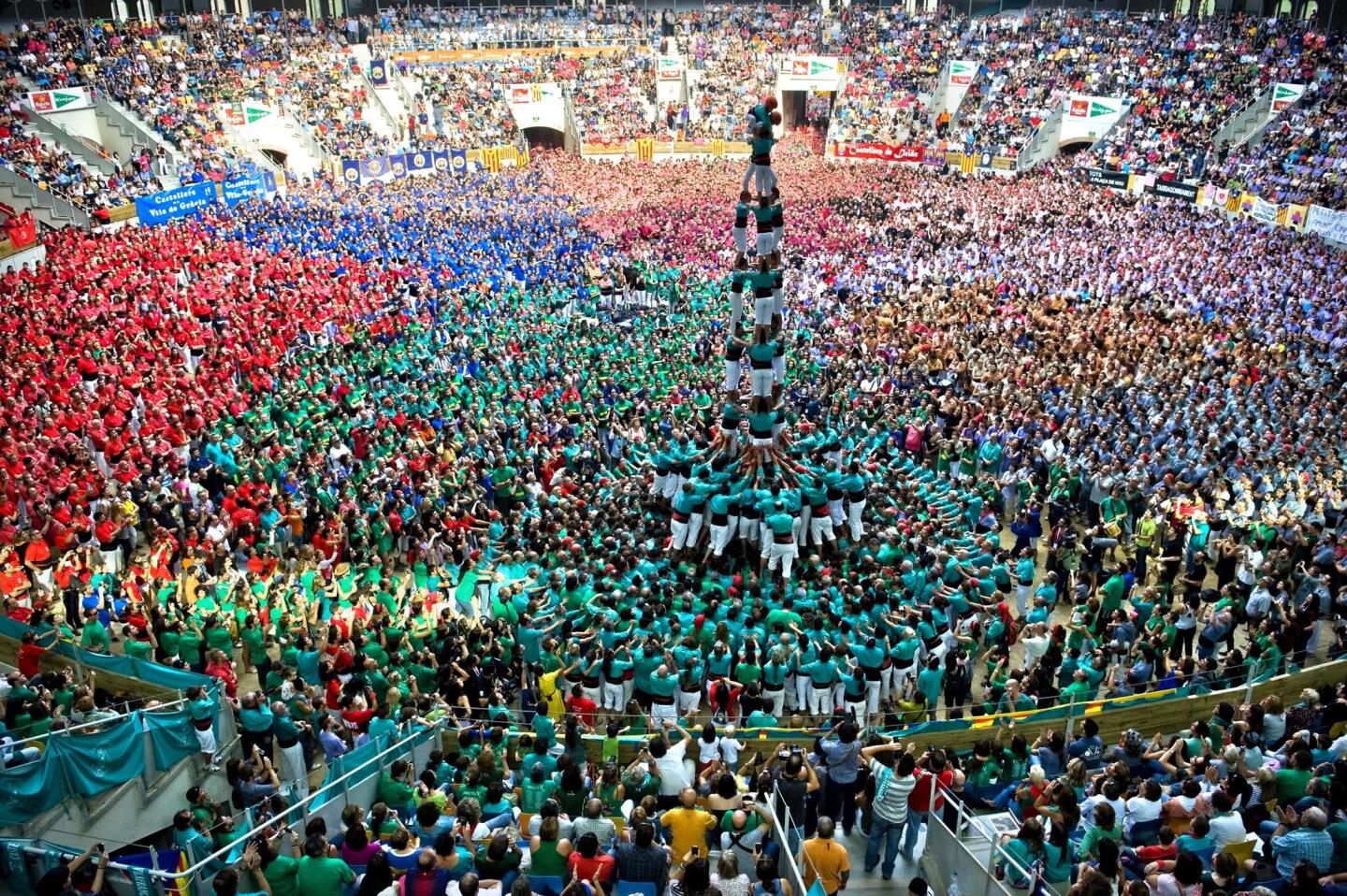 Team Castellers de Vilafranca (teal shirts) forms a human tower at the Tarragona Castells Competition.