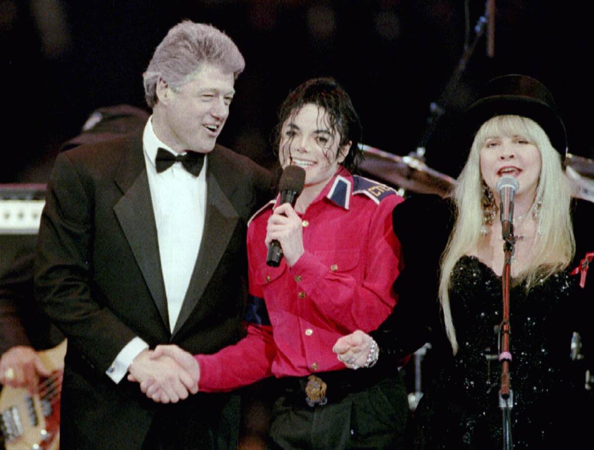 En esta foto de archivo aparece el expresidente Bill Clinton estrechando la mano de Michael Jackson.