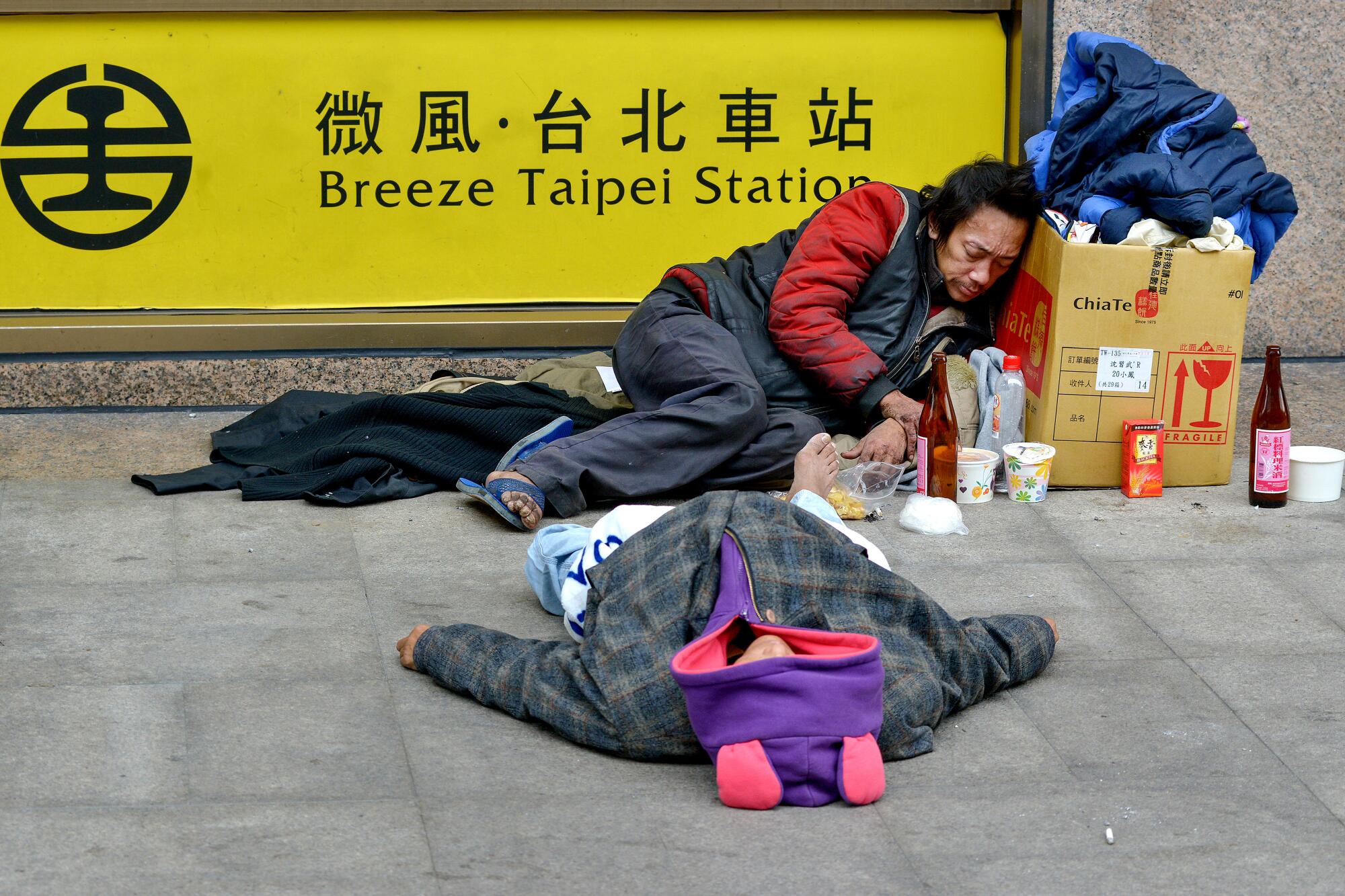 Homeless people drunk on cooking wine at the main train station in Taipei, Taiwan.