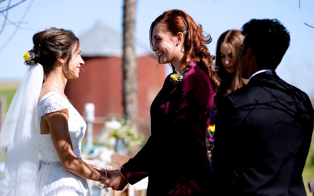 two women facing each other holding hands