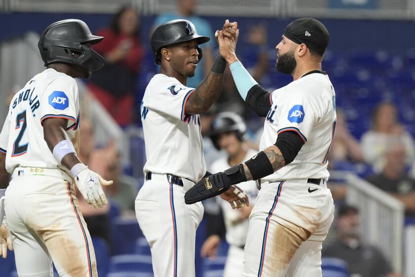 Miami Marlins' Tim Anderson, left, and and Emmanuel Rivera score on a hit by Luis Arraez during the sixth inning of a baseball game against the San Francisco Giants, Tuesday, April 16, 2024, in Miami. (AP Photo/Marta Lavandier)