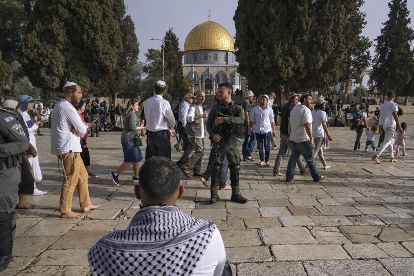 Israeli police escort Jewish visitors marking the holiday pf Passover to the Al-Aqsa Mosque compound, known to Muslims as the Noble Sanctuary and to Jews as the Temple Mount, in the Old City of Jerusalem during the Muslim holy month of Ramadan, Sunday, April 9, 2023. (AP Photo/Mahmoud Illean)