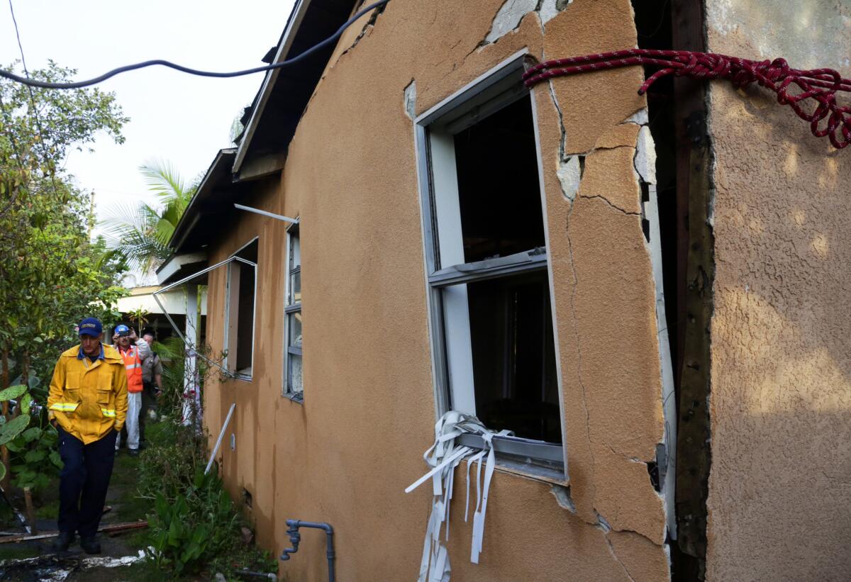 Los Angeles County fire hazmat technician Terry Wilkinson surveys the damage from an explosion caused by a suspected drug manufacturing process in the city of Commerce.