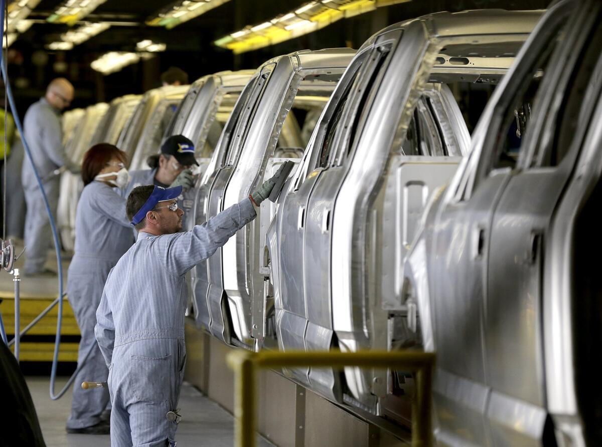 Workers inspect Ford F-150 trucks before they get painted at the company's Kansas City Assembly Plant in Claycomo, Mo.