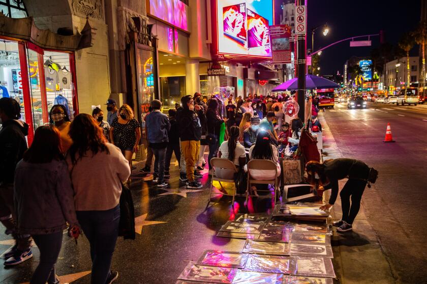 Hollywood, CA - March 20: The scene along Hollywood Blvd, in the heart of Hollywood, CA, as COVID-19 restrictions are loosened and people filled the sidewalks Saturday, March 20, 2021. This is one year and one day, after California Gov. Gavin Newsom issued a stay at home order, "to protect the health and well-being of all Californians and to establish consistency across the state in order to slow the spread of COVID-19." As of March 19, 2021, 57,510 people died from the coronavirus, with more than 3million positive cases. (Jay L. Clendenin / Los Angeles Times)