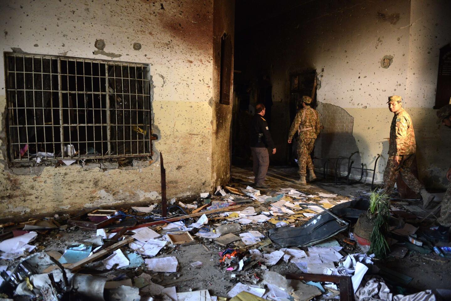 Pakistani security officials inspect the premises of the Army Public School that was attacked by Taliban militants in Peshawar.