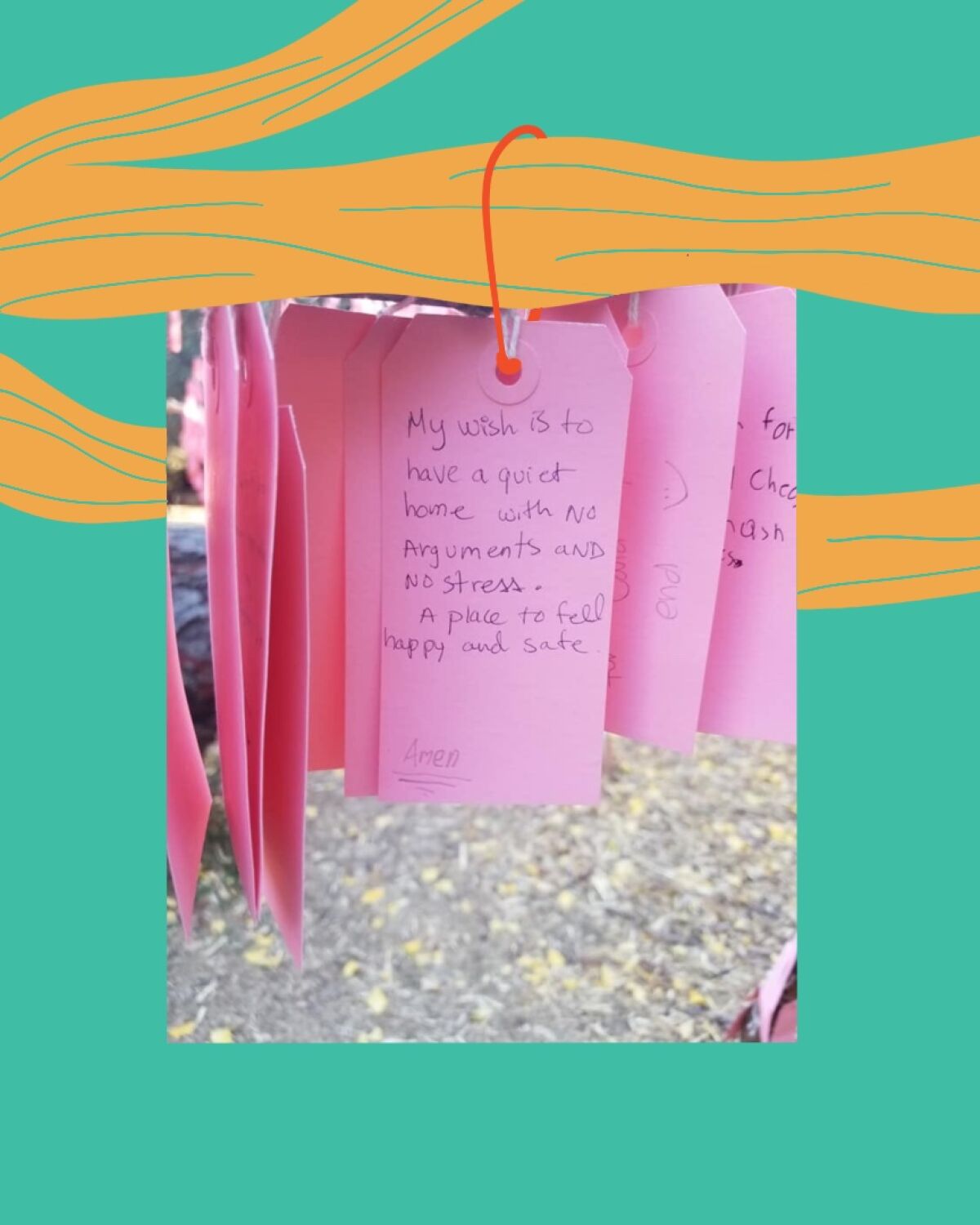 Wishes handwritten on pink cards hang on a tree. 