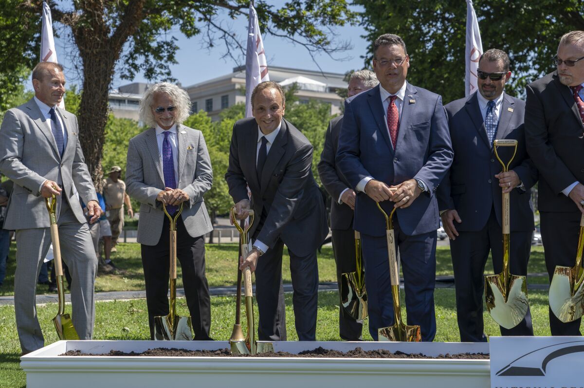 Scott C. Stump, far left, President of the National Desert Storm Memorial Association, Salem Abdullah, second from left, Kuwait ambassador to the United States, Gulf War veterans, and invitees participate in a groundbreaking ceremony for the new National Desert Storm and Desert Storm Memorial Thursday, July 14, 2022, on the National Mall in Washington. The new memorial will honor those who served on active duty in support of Operation Desert Storm or Operation Desert Shield. (AP Photo/Gemunu Amarasinghe)