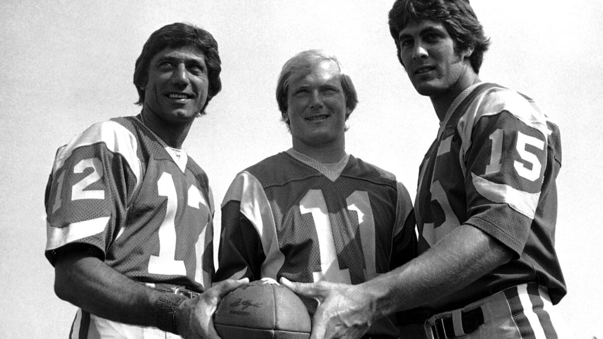 Rookie Vince Ferragamo (15) poses with veteran Rams quarterbacks Joe Namath (12) and Pat Haden (11) during training camp in 1977.