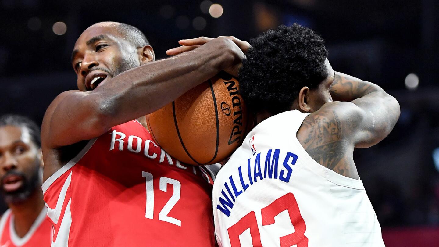 Houston Rockets' Luc Mbah a Moute (12) and Clippers' Lou Williams battle for a rebound.