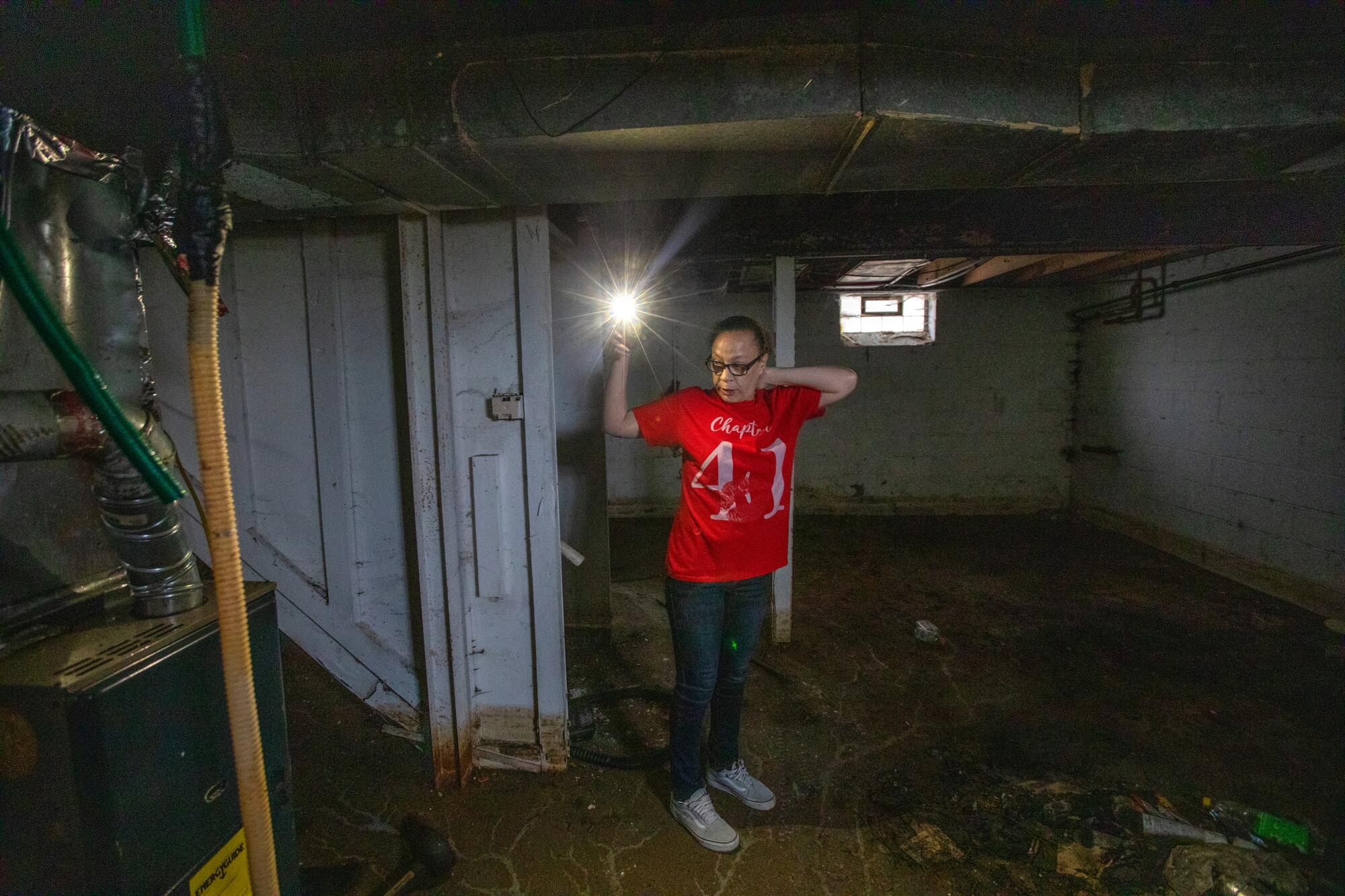 Nateka Williams shines a light in a basement.