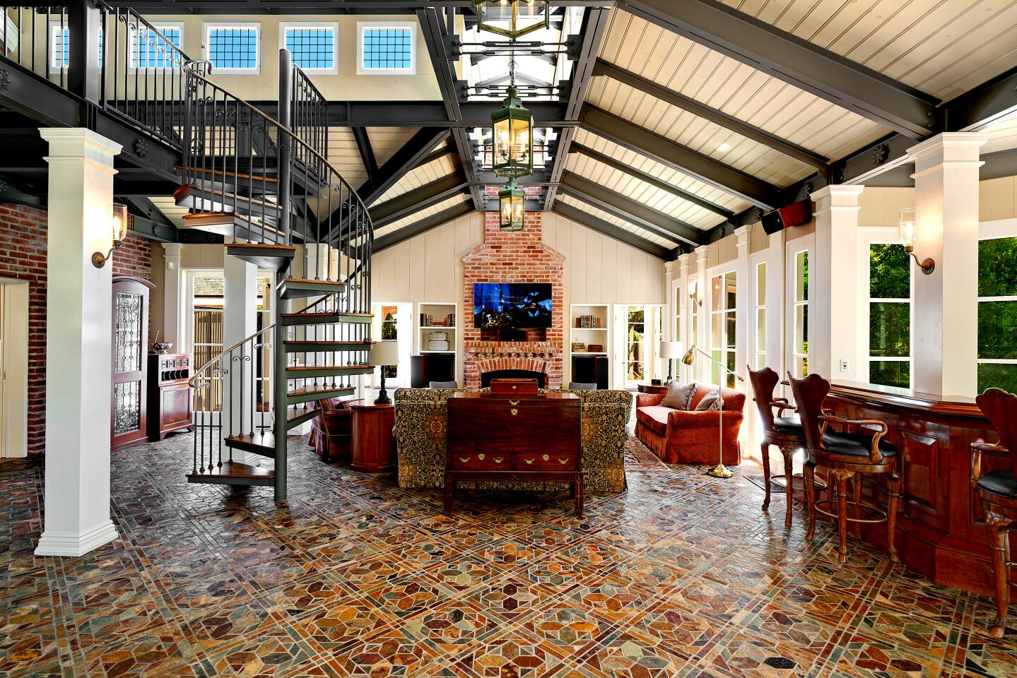 The main level contains an updated great room with a wrought-iron spiral staircase and a bar.