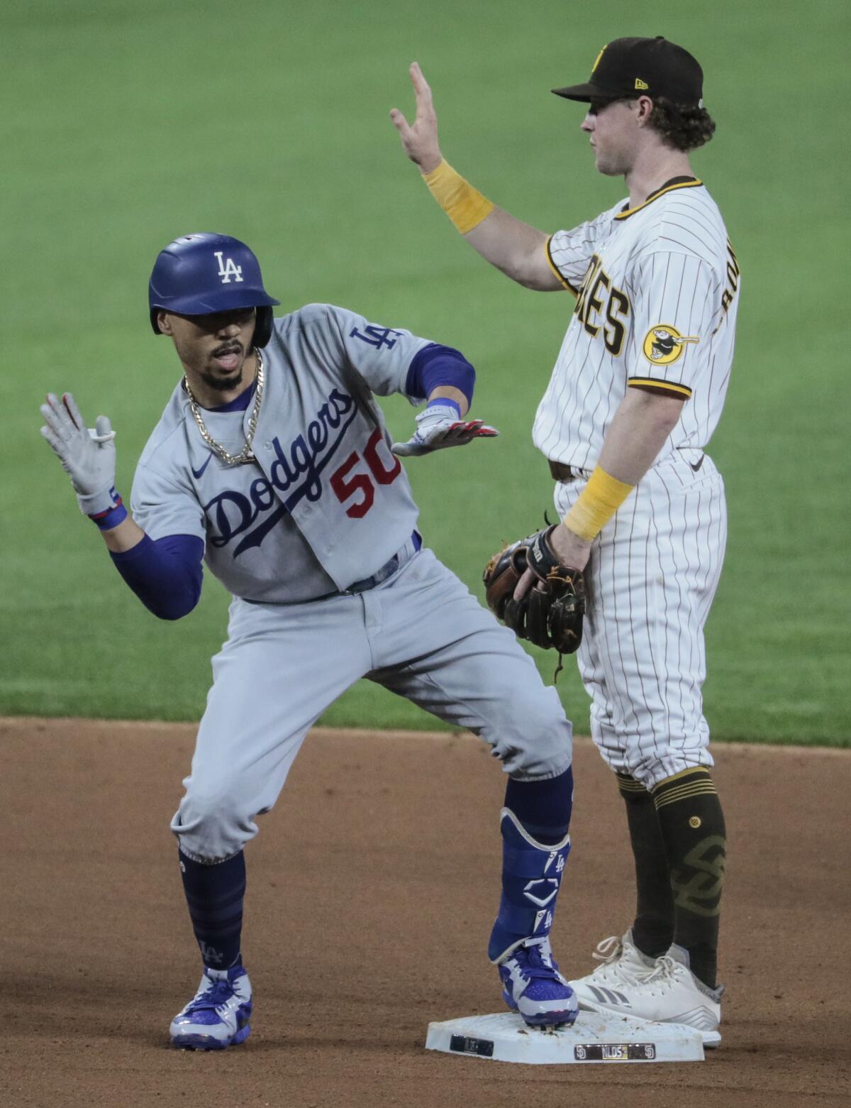 Dodgers right fielder Mookie Betts celebrates in front of Padres second baseman Jake Cronenworth.