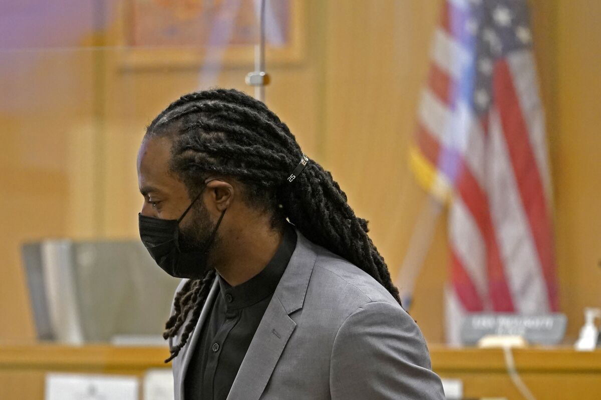 FILE - Richard Sherman stands up to leave a King County District Court hearing, Friday, July 16, 2021, in Seattle. Sherman, now with the Tampa Bay buccaneers, pleaded guilty Monday to two misdemeanor charges stemming from a drunken driving and domestic disturbance last summer as part of an agreement that spares him further jail time. (AP Photo/Ted S. Warren, File)