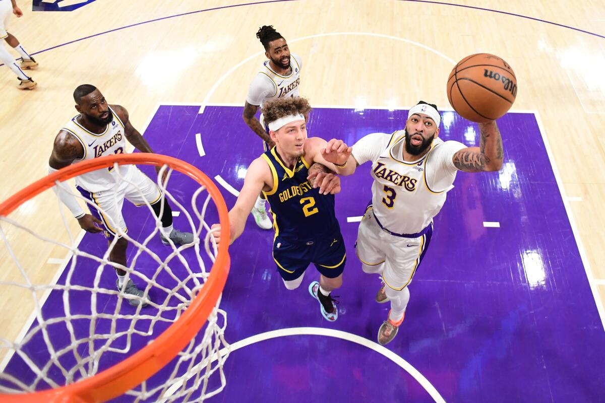 Lakers star Anthony Davis, right, rebounds over Golden State's Brandin Podziemski.
