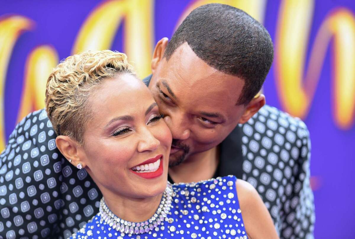 Genie actor Will Smith kisses his wife, Jada Pinkett Smith, at the world premiere of "Aladdin."