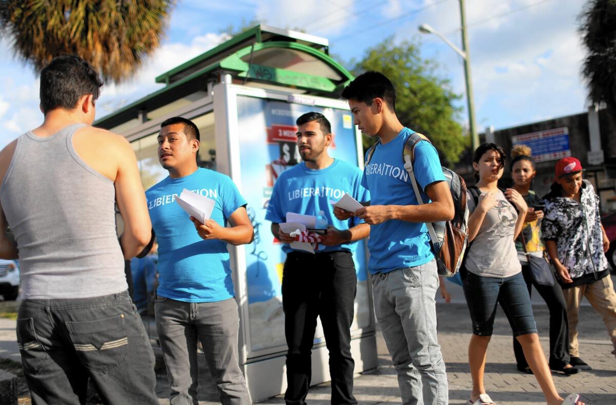 In Miami, activists, from left, Armando Carrada, Michael Sanchez and Hector Melgoza hand out pamphlets with information about U.S. District Judge Andrew Hanen of Texas, who temporarily halted President Obama's executive actions on immigration.