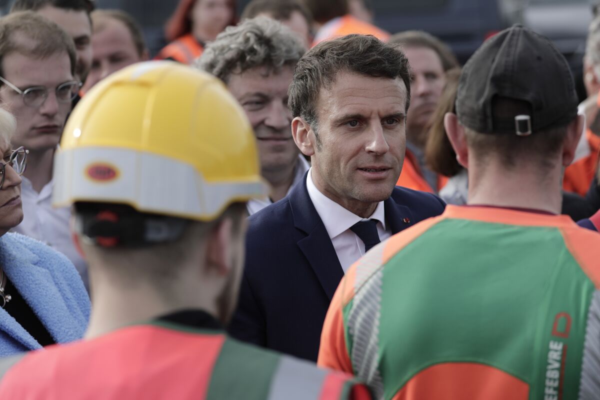 Current French President and centrist presidential candidate for reelection Emmanuel Macron meets workers as he visits a building site for Log's company in Denain, northern France, Monday, April 11, 2022 . French President Emmanuel Macron declared Monday that he wants to "convince" a broad range of French voters to back his centrist vision, kicking off a two-week battle against far-right challenger Marine Le Pen ahead of the country's presidential runoff vote. (AP Photo/Lewis Joly, Pool)