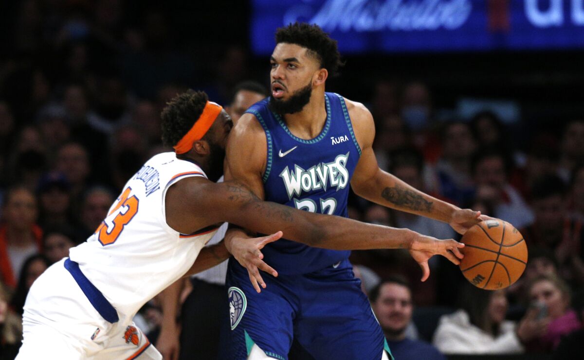 New York Knicks center Mitchell Robinson defend against Minnesota Timberwolves center Karl-Anthony Towns (32) during the second half of an NBA basketball game, Tuesday, Jan. 18, 2022 in New York. The Minnesota Timberwolves won 112-110. (AP Photo/Noah K. Murray)