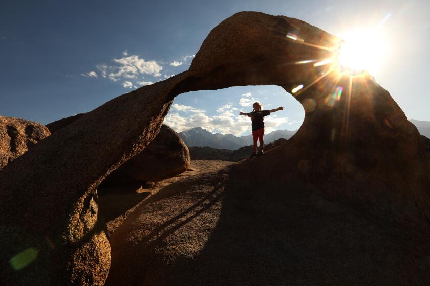 LONE PINE, CA - JUNE 21, 2020 - - Charlie Heller, 7, from Simi Valley, is framed by the Mobius Arch which is part of Alabama Hills National Scenic Area comprised of a range of hills and rock formations near the eastern slope of the Sierra Nevada in the Owens Valley, west of Lone Pine in Inyo County, California, on June 21, 2020. Leaders of the nonprofit Friends of the Inyo, which led a 10-year grassroots campaign to have Congress designate the Alabama Hills a National Scenic Area, want to change the name. That's because the Alabama Hills got their name from Confederate sympathizers after the Confederate raider CSS Alabama had sunk the Union man-of-war Hatteras off the coast of Texas in 1863. (Genaro Molina / Los Angeles Times)