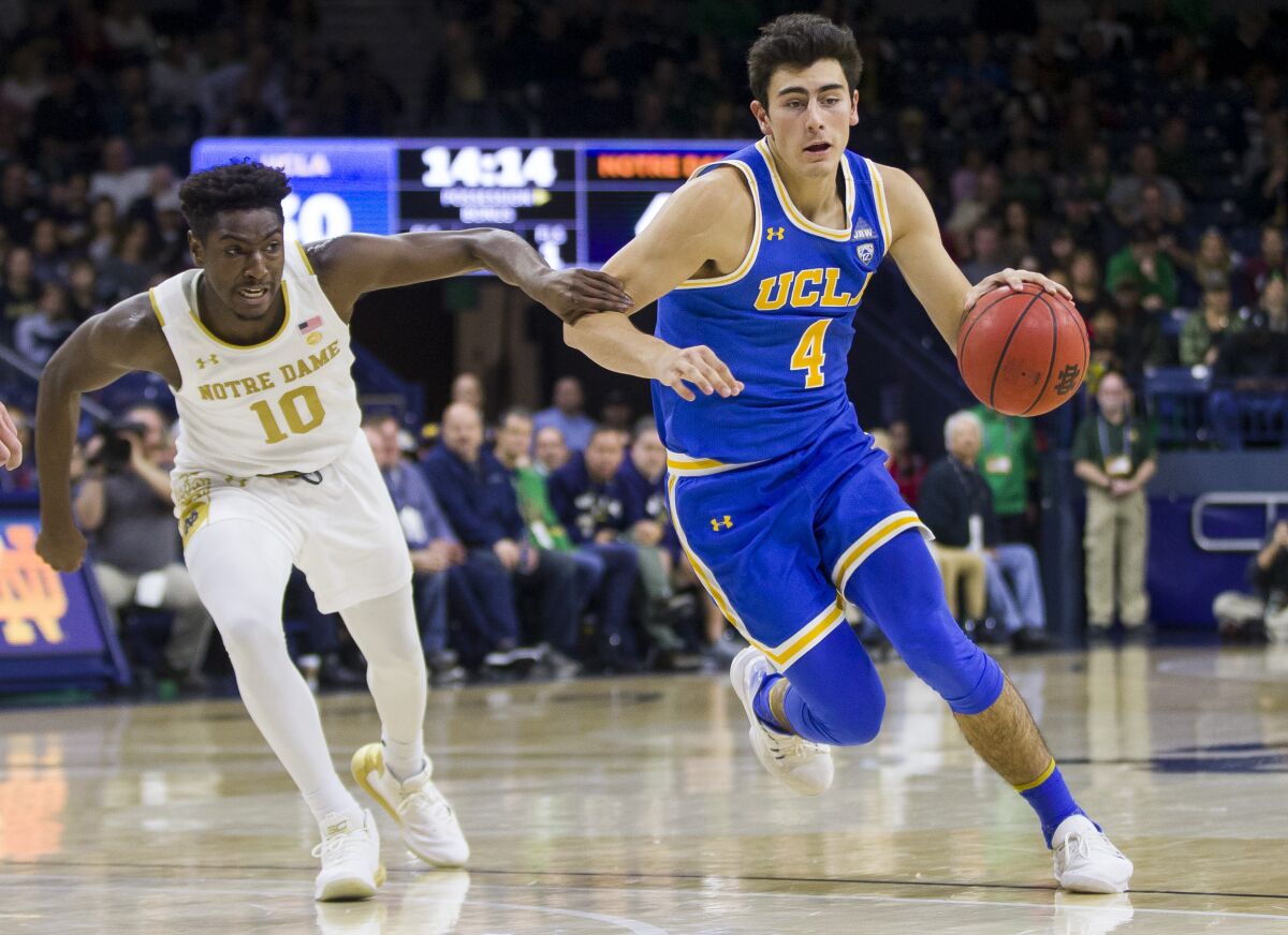 Freshman Jaime Jaquez Jr. dribbles past Notre Dame's Temple Gibbs on Dec. 14, 2019, in South Bend, Ind.