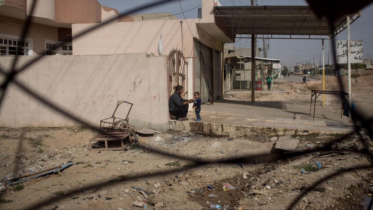 A man and his child are seen just behind the frontline in the Entisar neighborhood in Mosul, Iraq, on Nov. 15, 2016.